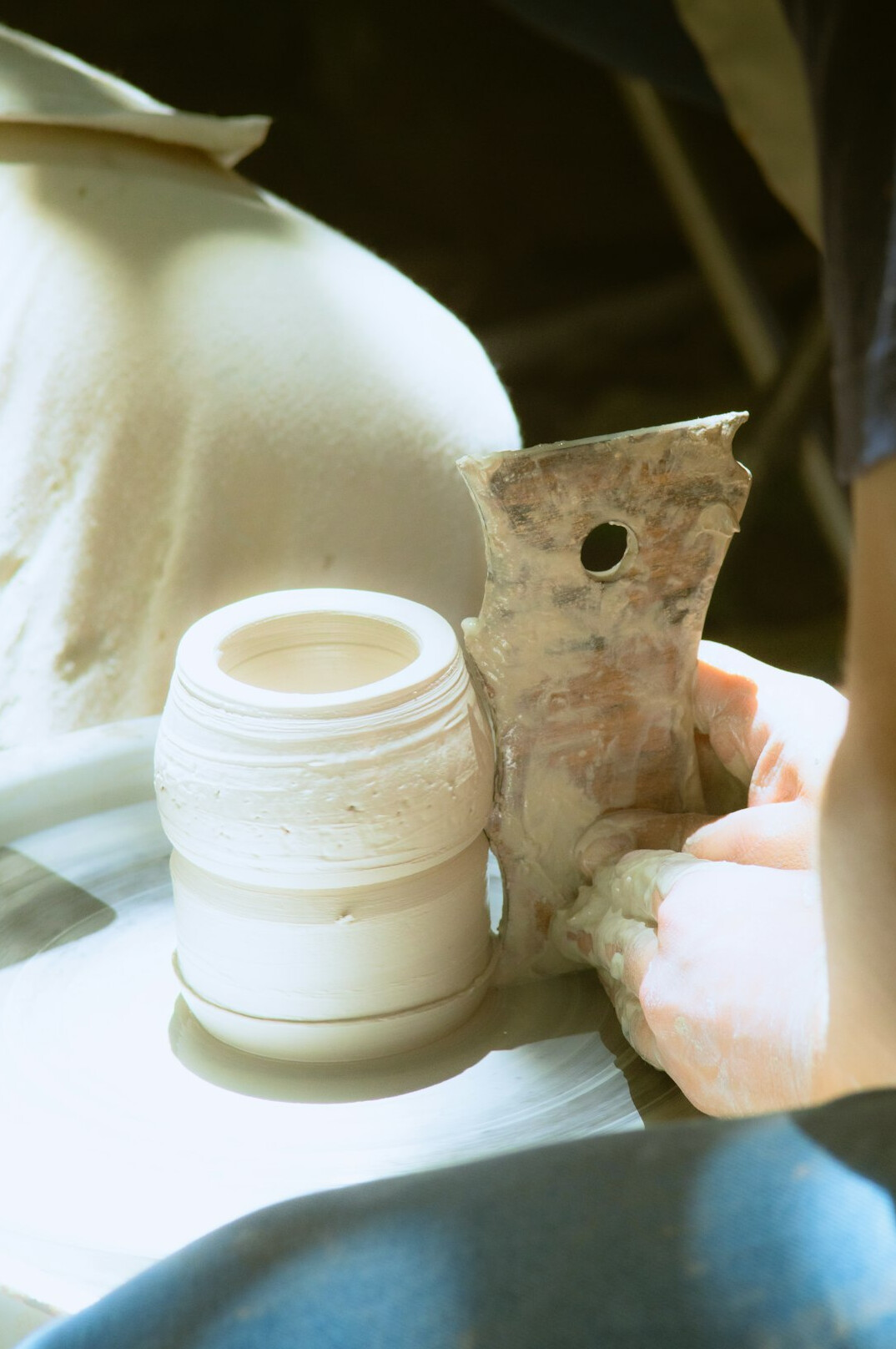 Technician sanding a car body panel in a workshop
